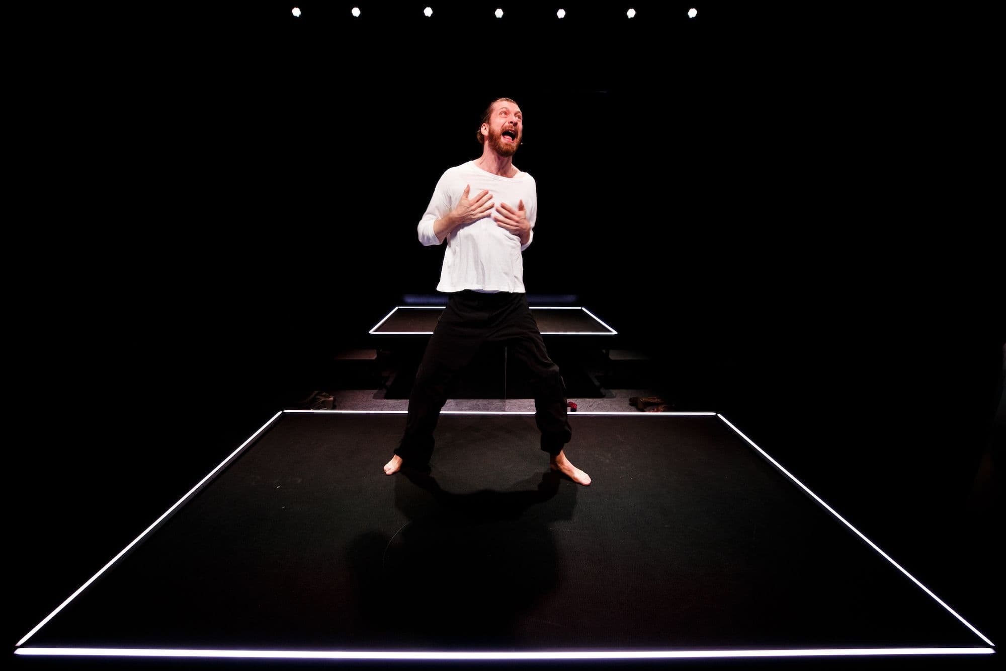 Vincent van der Valk staat in een wit t-shirt op het podium en grijpt naar zijn borst