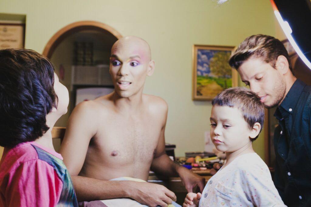 Een zwarte en witte man zitten samen met twee jonge kinderen, ze lachen